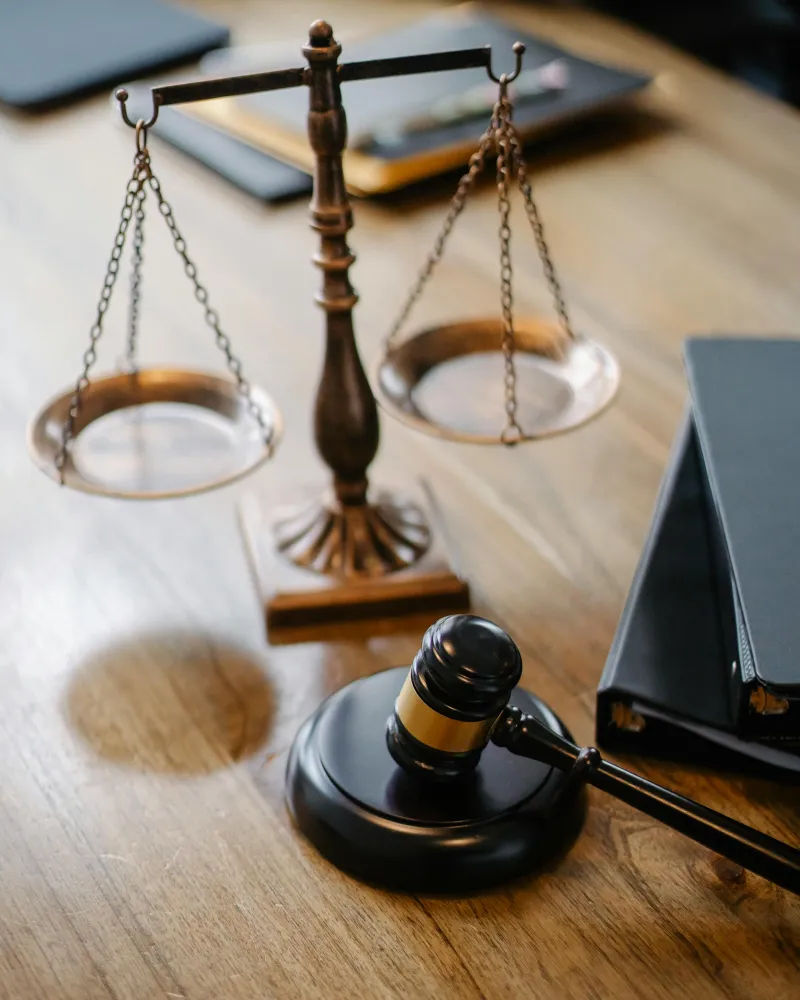Bilancia della giustizia e martelletto del giudice su scrivania in legno - liquidazione controllata sotto controllo del tribunale